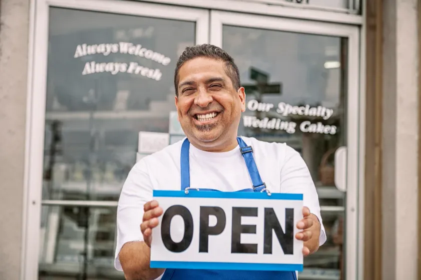 Restaurant owner holding open sign